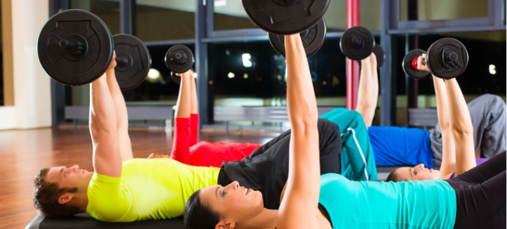 A group exercise class lift weights