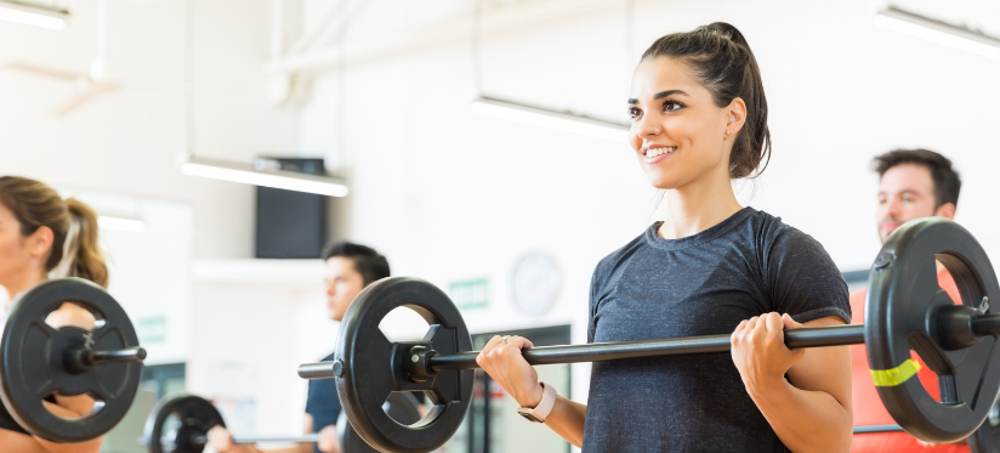 People lifting weighted bar in exercise class