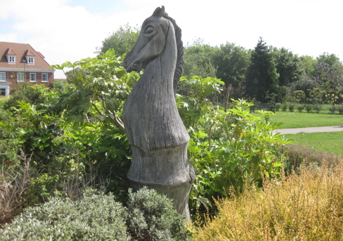 Large wooden sculpture of a knight chess piece in a public park