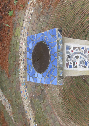 Stone plinth decorated with mosaic tiling, inside a mosaic circle