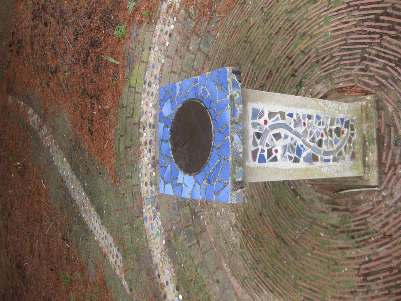 Stone plinth decorated with mosaic tiling, inside a mosaic circle