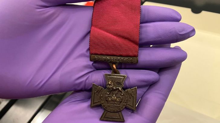 A close up of the front of a Victoria Cross medal. 
