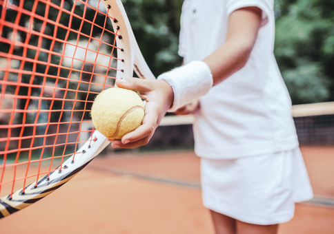 Child with tennis racket and ball