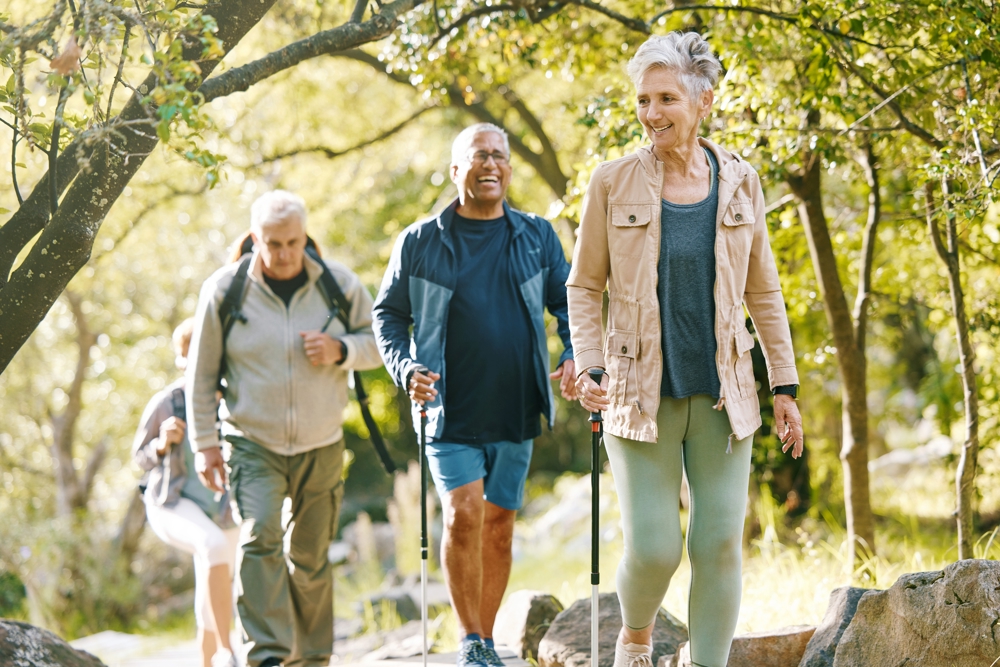 Group of older people out for a walk, some using walking poles