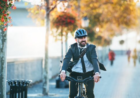 Man in suit riding bike in urban area