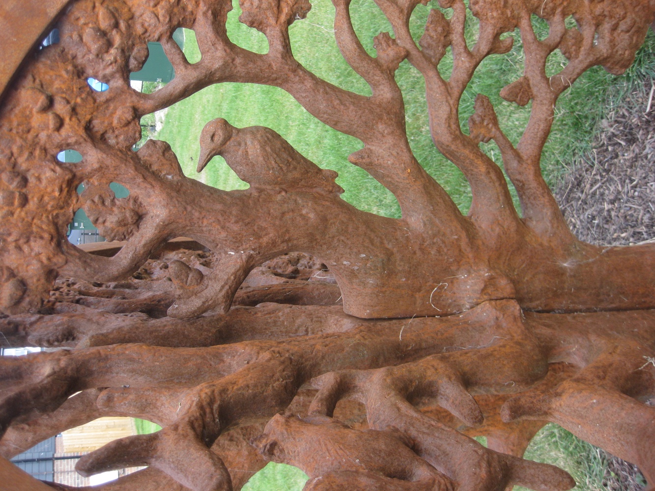 Spherical sculpture made from a metal depicting oak tree