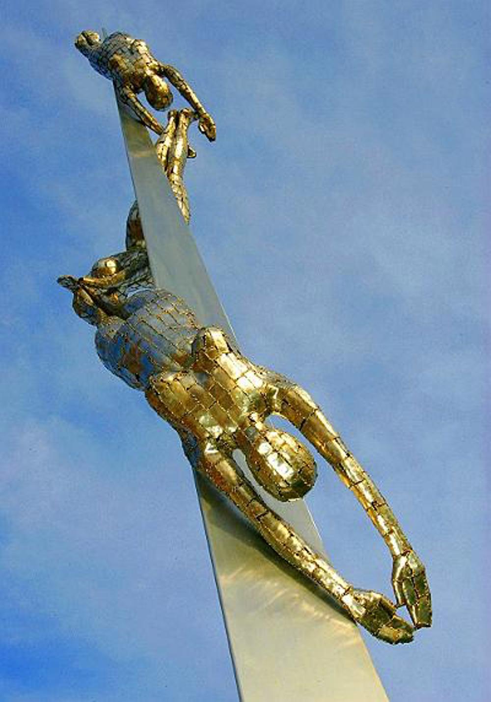 Sculpture of three swimmers in diving position, wrapping around pillar