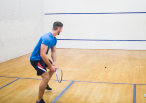 Man and woman playing on squash court