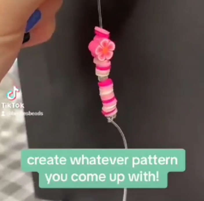 TikTok still showing pink beads being threaded with caption "create whatever pattern you come up with!"