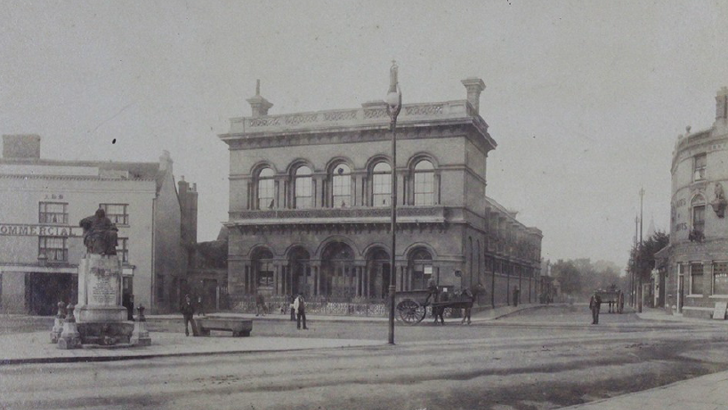 Large stone building, with statue of Judge Tidal in front (black and white photo)