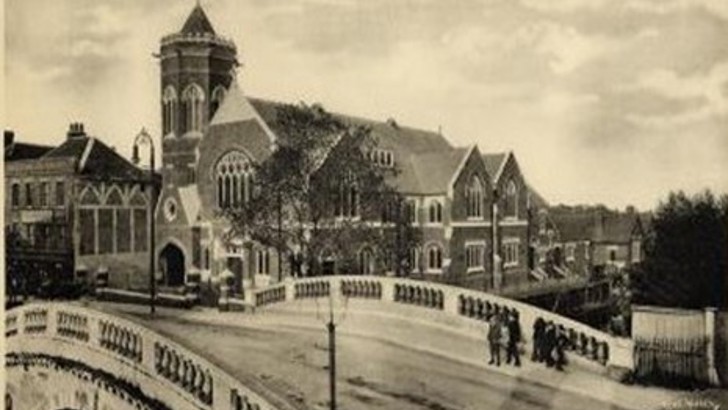 People walking over Stone Bridge (old black and white photo)