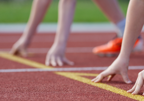 Kids lining up at the start line on an athletics track