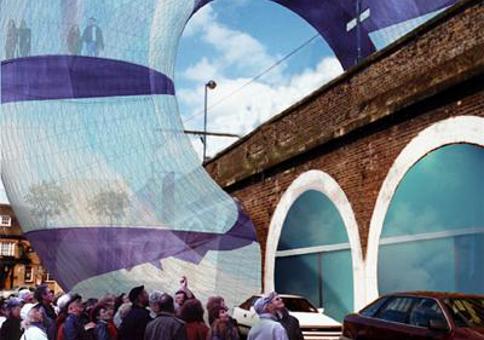 Artist's impression of crowd of people looking a large ring-like structure over a bridge