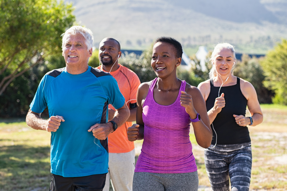 Four people running together outdoors