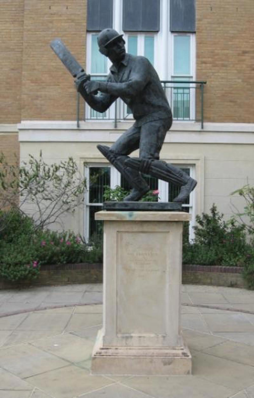 Statue of cricketer Graham Gooch on a plinth outside a house