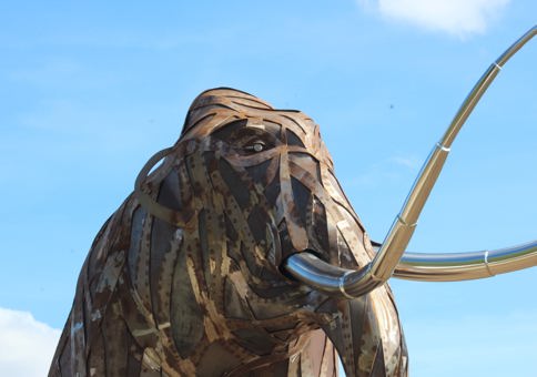 Large metal mammoth sculpture with metalwork skin comprising of a stream of overlapping strips